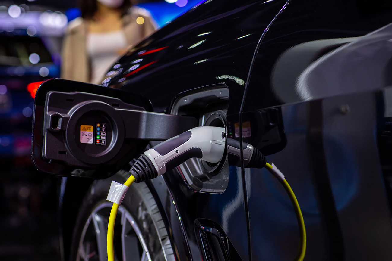Black electric vehicle charging at a charging station, illustrating Carey's commitment to SBTi initiatives.